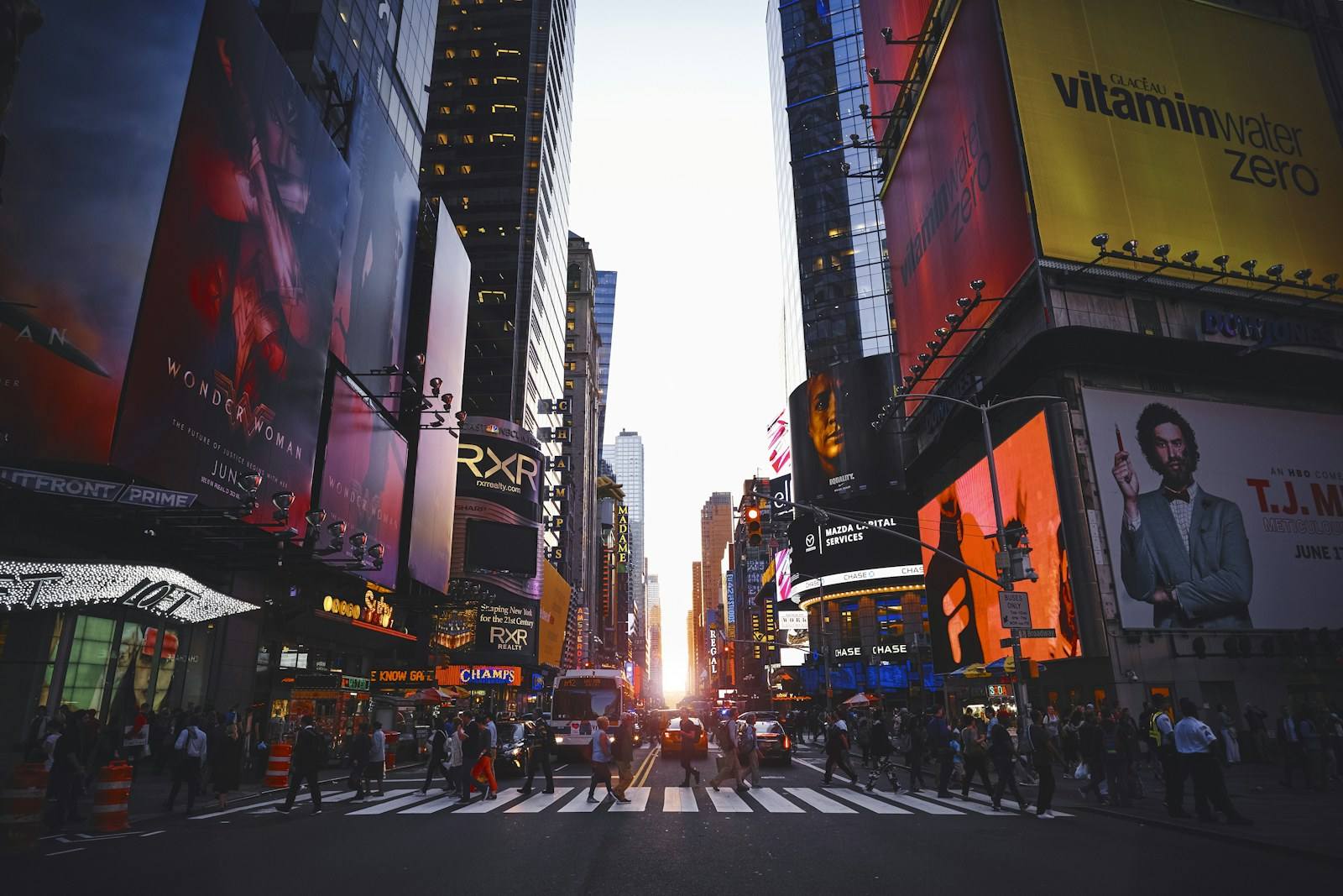 Times Square in New York City at dusk, with illuminated billboards and crowds